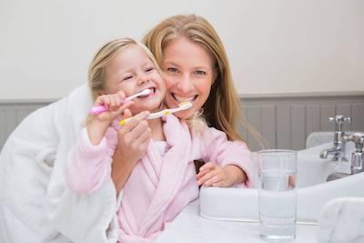 mother and daughter brushing teeth | lower plenty