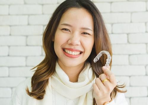 invisalign lower plenty | woman holding aligner